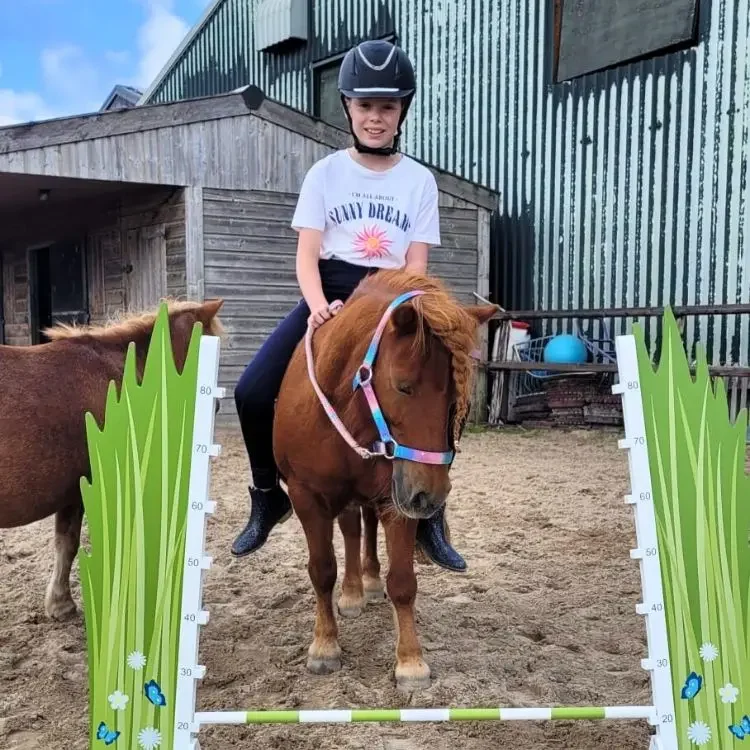 meisje op een pony voor een lage horde
